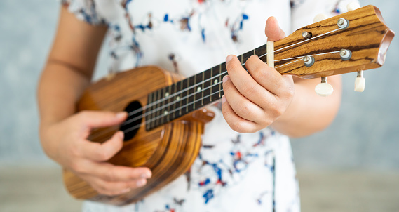 Músico de mujer feliz tocando el ukelele y canta una canción en el estudio de sonido. Concepto de estilo de vida la música. photo