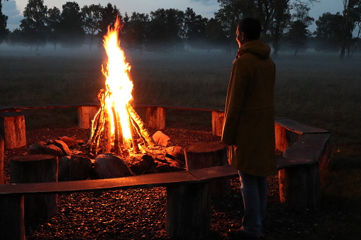 One person waiting for friends to join at the camp fire, Germany