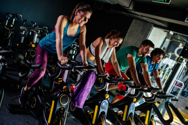 istock Group of young people exercising on exercise bikes at gym 1128168726