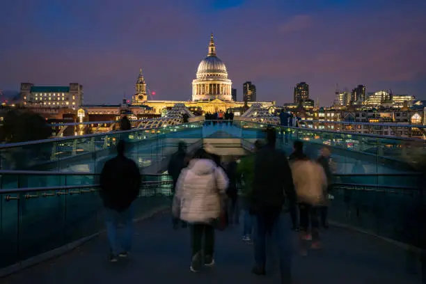 Motion blurred image providing a view of the busy Millennium Bridge on Thames Southbank towards the London city skyline with St Paul's Cathedral. Shot with Canon EOS R full frame system.