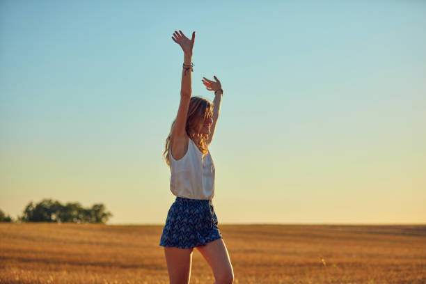 istock Cute young woman jumping in a wheat field. 1128173945