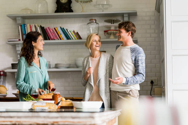 istock Cheerful friends talking in kitchen at home 1128174417