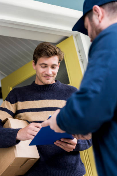 istock Postal worker taking signature from customer 1128175410