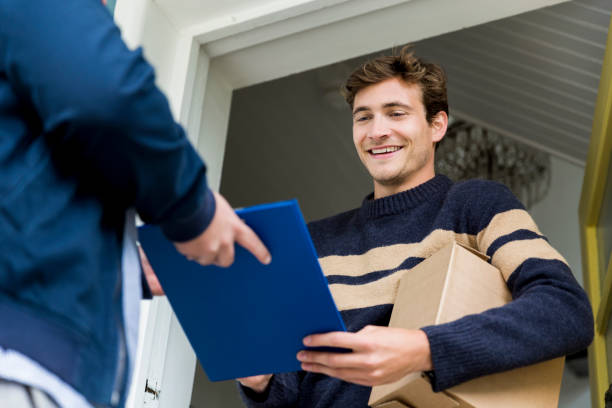 Postal worker taking signature from man at doorway