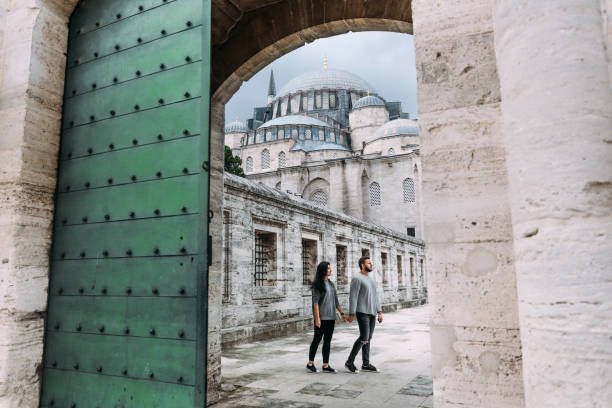 Traveling couple near the mosque. Beautiful mosque in Istanbul. Wedding trip the newlyweds. Tourists in Turkey. Follow me. Boy and girl holding hands. Tourists on the tour. Man and woman in the mosque stock photo
