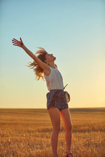 istock Cute young woman jumping in a wheat field. 1128176007