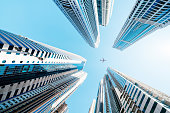 Skyscrapers with a airplane silhouette in Financial District under Sun Flare,Dubai