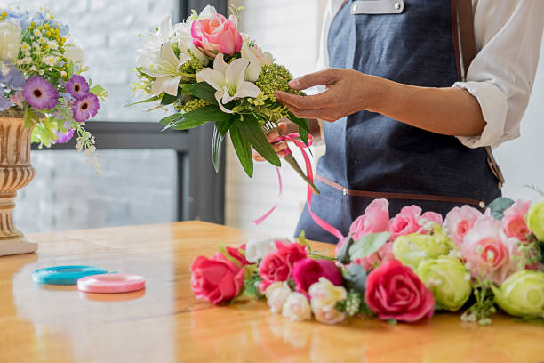ワーク ショップの花屋で花の組成を作る女性の手。コンセプトは自分で行う - flower arranging ストックフォトと画像