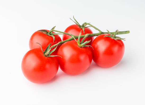 istock A branch of cherry tomato lies on a white surface. 1128182613