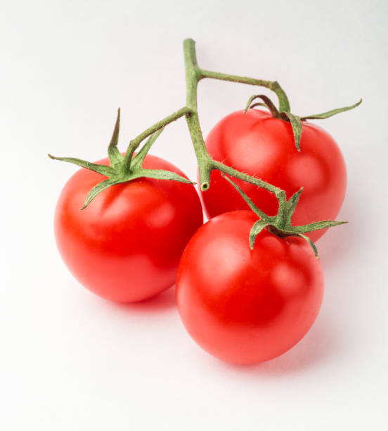 istock A branch of cherry tomato lies on a white surface. 1128182858