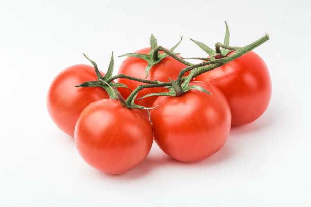 istock A branch of cherry tomato lies on a white surface. 1128182941