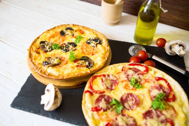 istock Mushroom and vegetable pizza and salami pizza at back 1128184659
