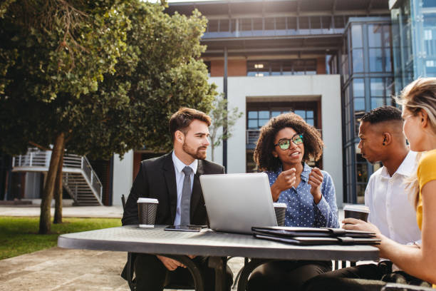 istock Business professionals discussing work at office cafeteria 1128184901