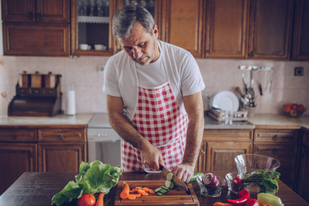 istock Mature man making a healthy salad 1128185858