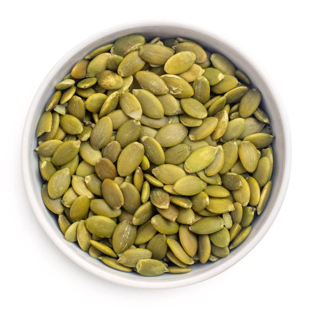 istock Raw pumpkin seeds in bowl isolated on white background. top view 1128186885