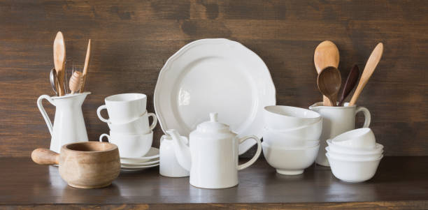 istock Crockery, clayware, white utensils and other different stuff on wooden tabletop. Kitchen still life. 1128186913
