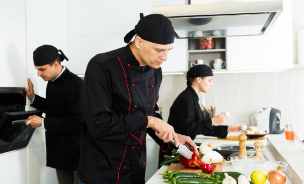 istock Male cook is making salad on his work place in the kitchen 1128189092