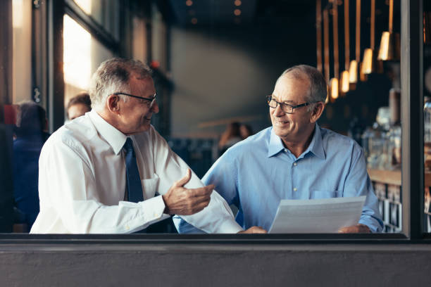istock Mature business partners working together at a cafe 1128192804