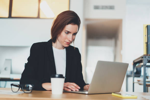 istock Handsome businesswoman using laptop computer at modern office.Blurred background.Horizontal. 1128196043
