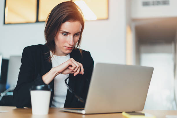 istock Pensive beautiful businesswoman using laptop computer at modern office.Blurred background.Horizontal. 1128196171