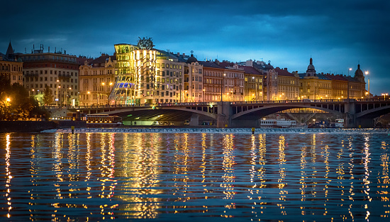 Dancing house in Prague at night reflected in the Vltava river. Pragua, Czech Republic.