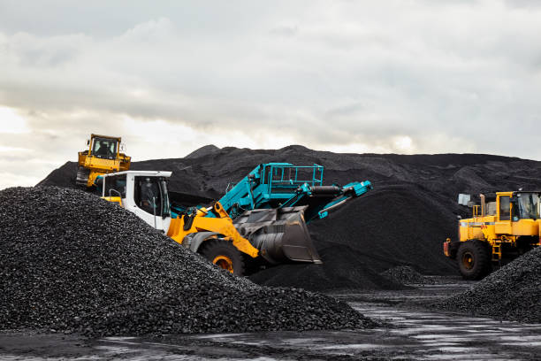 i trattori caterpillar raccolgono pile di carbone nero. illustrazione del campo di alimentazione della centrale elettrica. - carbonella foto e immagini stock