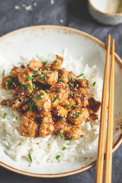 istock Sesame chicken pieces with rice on a ceramic plate. Chinese traditional dish. 1128199906