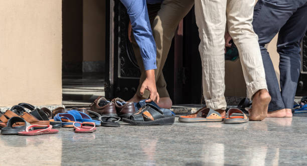 Men removing shoes at the entrance of a mosque in Dubai, United Arab Emirates stock photo