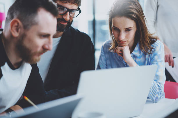 istock Teamwork process concept.Happy coworkers working with new startup project at sunny office.Horizontal, blurred background. 1128201419