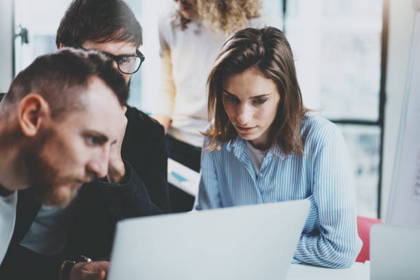 istock Group of young entrepreneurs are looking for a business solution during working time at sunny office.Business people meeting concept.Blurred background.Horizontal. 1128201469