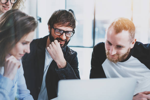 istock Business meeting concept.Coworkers team working with mobile computer at modern office.Analyze business plans,using laptop.Blurred background.Flares. 1128201770