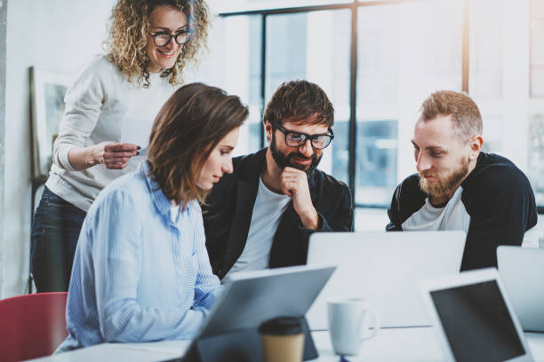 istock Group of young coworkers brainstorming process at sunny office.Blurred background. 1128201849