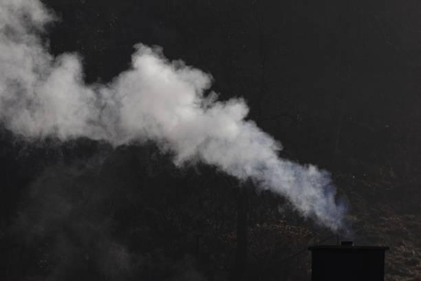 A white smoking chimney with a dark background.