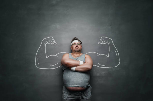 Funny sports nerd with huge muscle arms drawn on the gray background Funny sports nerd with huge muscle arms drawn on the gray background with copy space crossfit chalk weightlifting weight training stock pictures, royalty-free photos & images