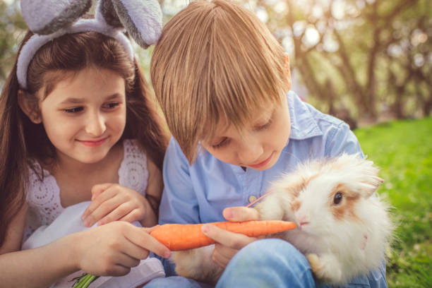 istock Happy children playing with bunny on Easter egg hunt 1128223291