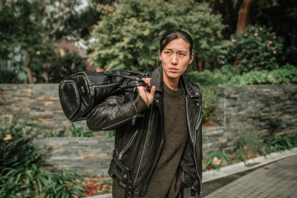 istock Asian man holding leather bag over his shoulder 1128228367