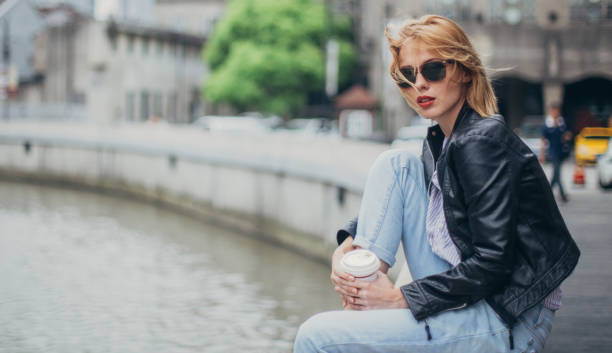 istock Beautiful blonde lady on coffee break outdoors in city 1128231238