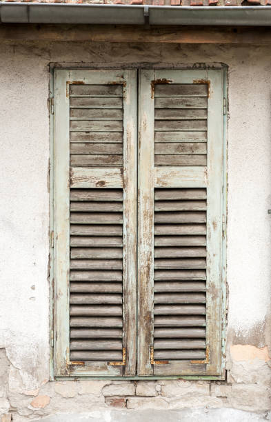 istock Old damaged wooden curtains or shades on abandoned house window vertical image 1128232143
