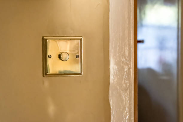 vista isolata di un interruttore della luce in ottone e dimmer visto di recente installato in una casa d'epoca - brass buttons foto e immagini stock