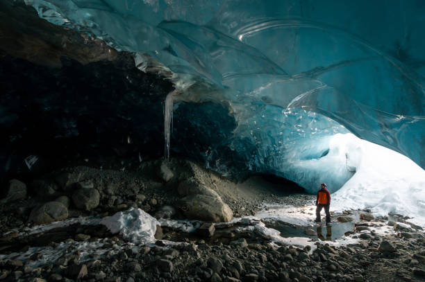istock Man exploring a stunning glacial ice cave 1128233688