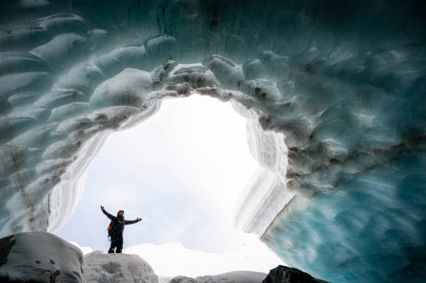 istock Man exploring a stunning glacial ice cave 1128233753