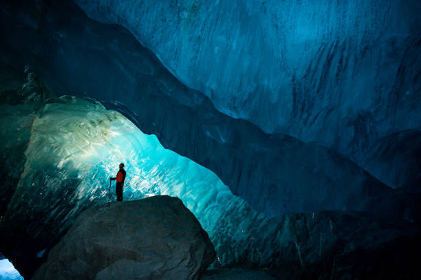 istock Man exploring a stunning glacial ice cave 1128233754