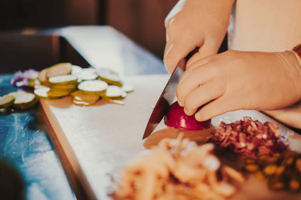 istock Chef starts cutting onion with a knife on the board 1128234166