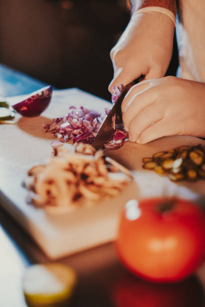 istock Chef cutting fresh onion with a knife on the board 1128234179