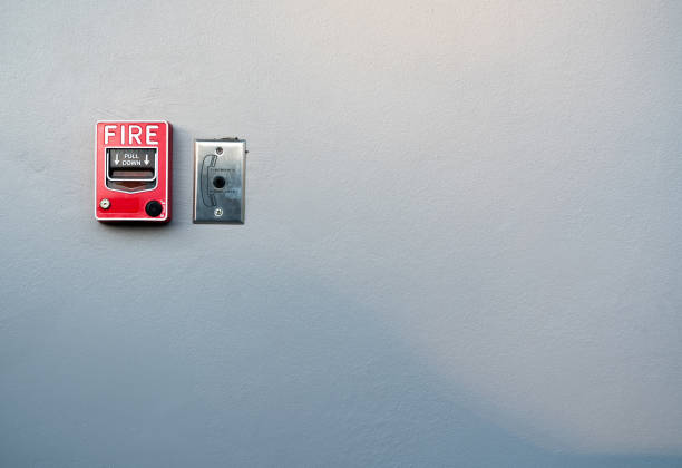 istock Fire alarm on white concrete wall. Warning and security system. Emergency equipment for safety alert. Red box of fire alarm on wall of school, hospital, factory, office, apartment, or home. Pull down. 1128235115