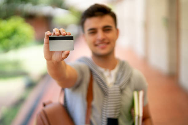 istock Cheerful latin american student holding a card to edit up front while smiling at camera 1128235727