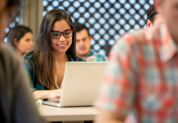 istock Happy latin american beautiful student using a laptop during class at college 1128235812