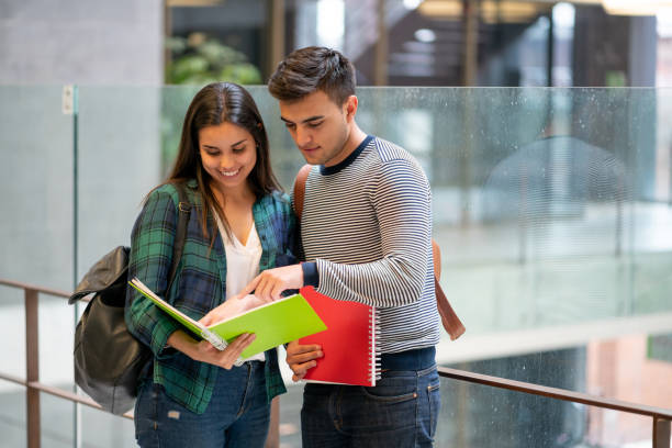 istock Latin american male student pointing something on notebook while friend smiles 1128235817