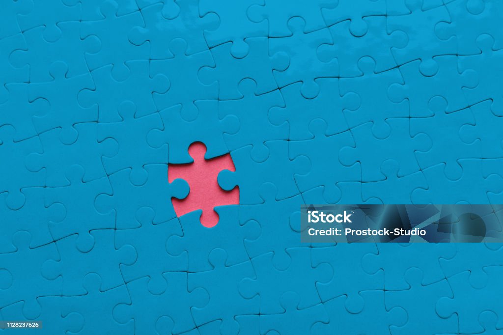 Buco rosa in sfondo puzzle blu, spazio di copia - Foto stock royalty-free di Distinguersi dalla massa