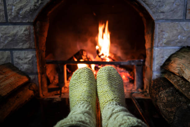 istock Foot in wool socks warming by the fireplace 1128238944